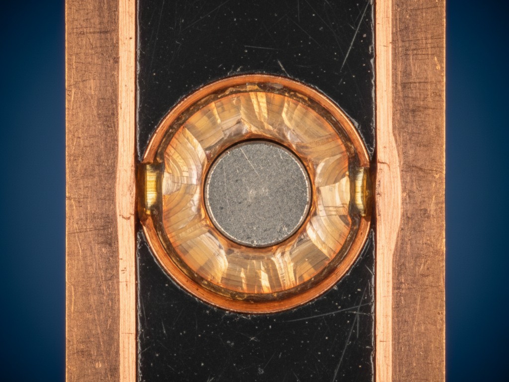 Металлографический поперечный срез пайки Микроскопический поперечный срез сквозного паяного соединения, показывающий вертикальные слои медной втулки, центрального вывода и заполнения припоем.